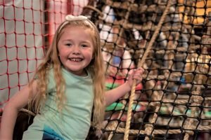 Girl climbing on ropes indoor play
